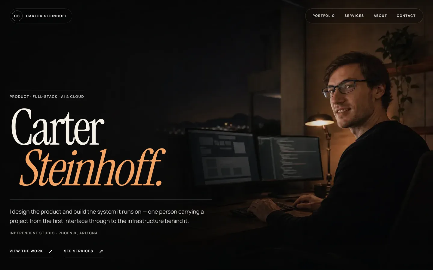 Carter Steinhoff homepage hero with the name set large in a serif display face over a photograph of a desk at night